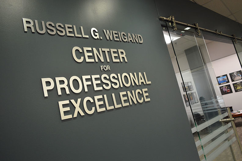 “Russell G. Weigand Center for Professional Excellence”的字样显示在埃尔姆赫斯特学院职业中心的办公空间外。