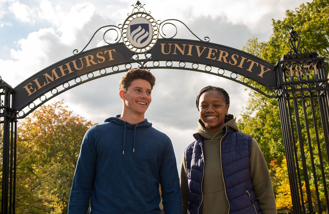 埃尔姆赫beplay体育飞翔下载斯特大学的两名学生，一男一女，在校园的知识之门下微笑。